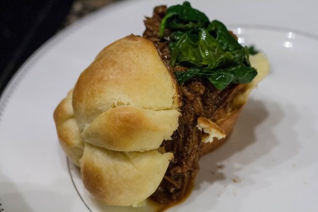 closeup pulled pork sandwich with spinach