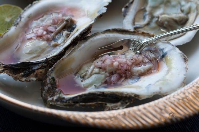 closeup raw oysters with tropical mignonette