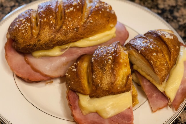pretzel roll sandwiches with ham, cheese and tomatoes