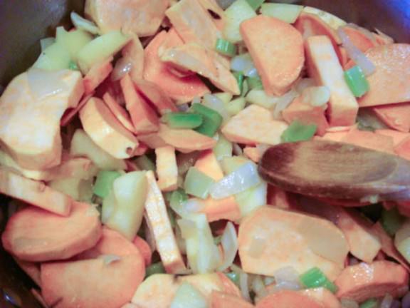 adding sweet potatoes to veggie sautee