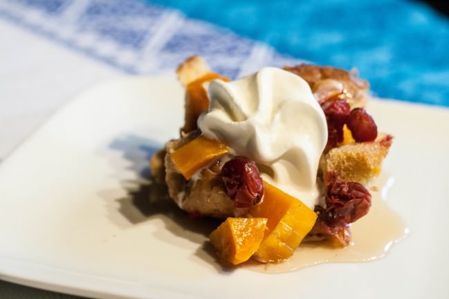 cranberry butternut squash bread pudding with maple syrup and whipped cream