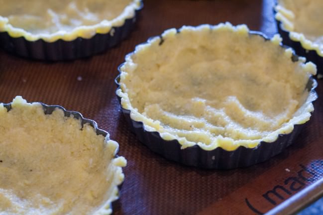 Spicy Polenta Tarts with Okra and Sweet Corn lining tart pans with dough