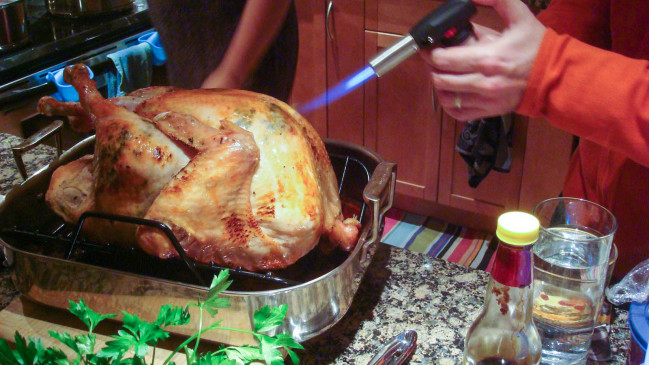 Bacon Herb Paste Stuffed Turkey herbs and bacon torching the turkey